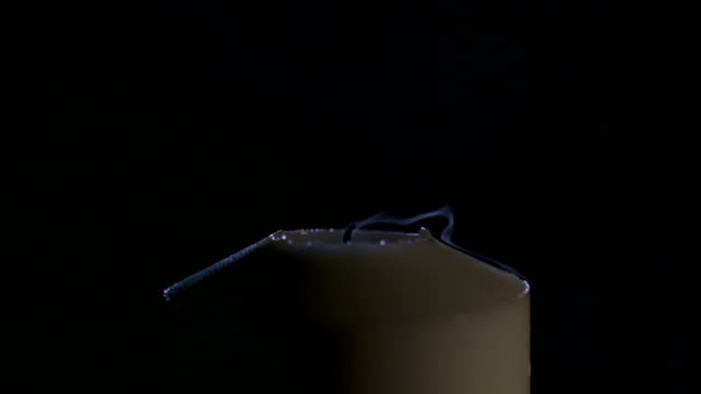 Slow-motion-macro-footage-of-a-white-candle-on-a-dark-background