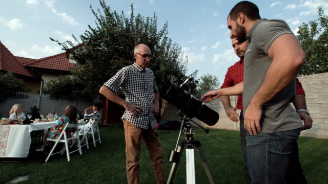 Männer-zusehen-Teleskop-auf-dem-Hinterhof