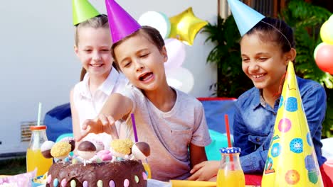 Niños-con-torta-de-cumpleaños-en-el-patio-trasero-de-casa-4k