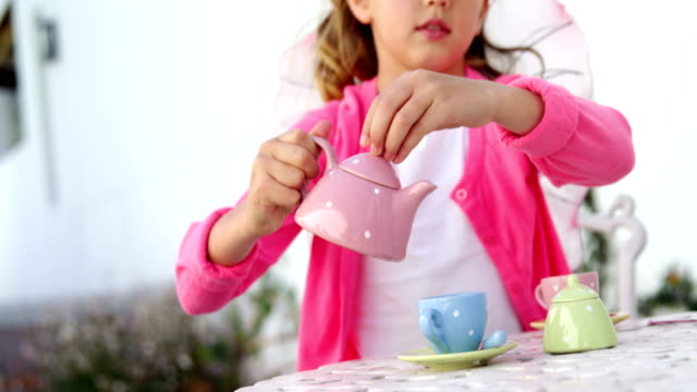 Girl-in-fairy-costume-pouring-tea-into-cup-4k