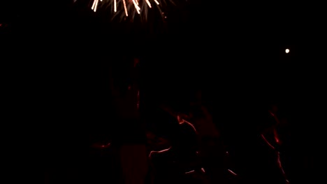 Jubelnden-Menschen-mit-Armen-ausgestreckt-im-freien-feiern-mit-Feuerwerk