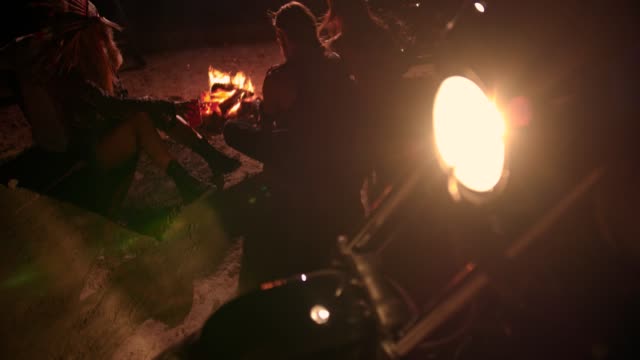 Gruppe-von-Motorradfahrer-Rebel-Freunden-sitzen-und-trinken-Lagerfeuer