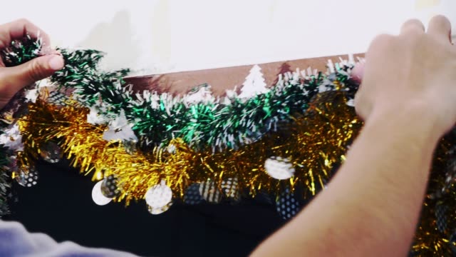 4K-Hands-of-person-hanging-Christmas-decoration-on-the-wall.-Vintage-toned-footage.