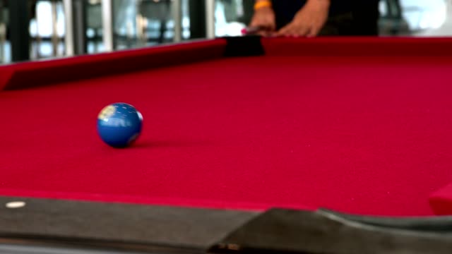 Playing-the-pool-billiard-game-on-red-baize-table.-This-is-sports