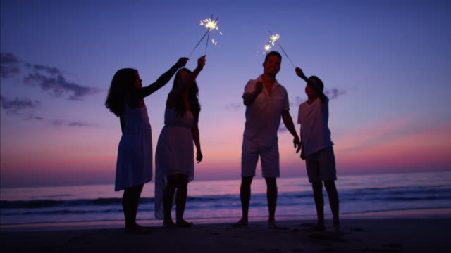 Silhouette-of-Spanish-family-on-beach-with-sparklers