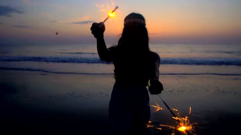 Silhouette-of-Asian-Indian-female-sparklers-on-beach