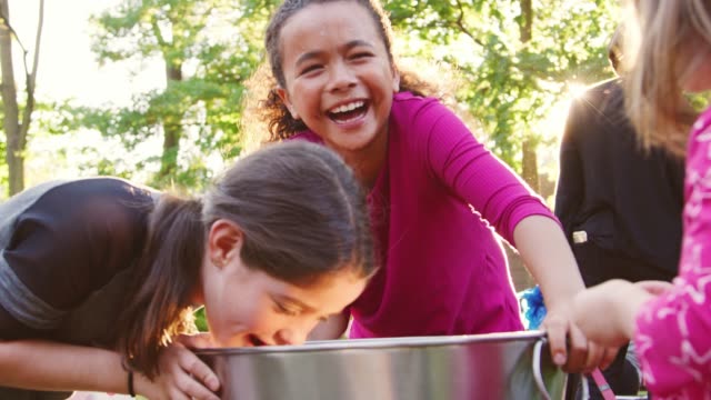 Three-young-girls-apple-bobbing-at-a-backyard-party