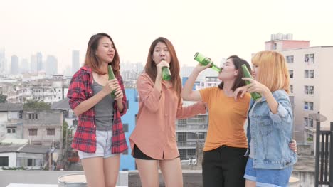 A-group-of-Asian-woman-are-drinking-beer-and-dancing-happily-on-the-rooftop.