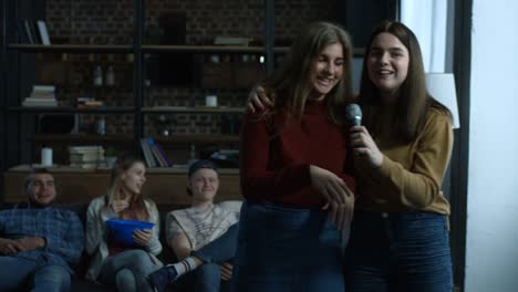 Chicas-alegres-cantando-karaoke-en-la-sala-Nacional