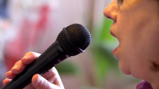 Senior-woman-signing-with-microphone-karaoke-in-slow-motion-4k-slow-motion