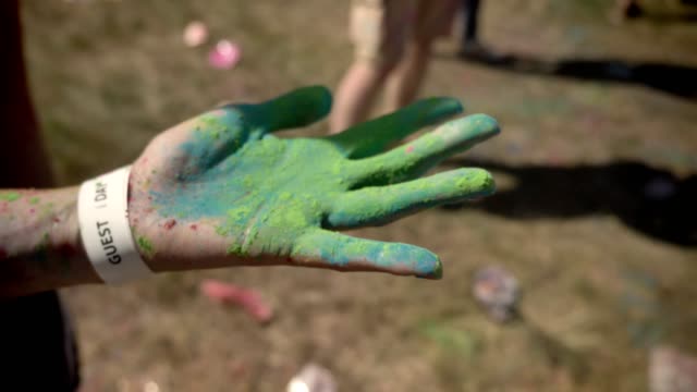 Someone-shows-hand-in-colorful-powder-on-holi-festival-in-daytime-in-summer,-color-concept