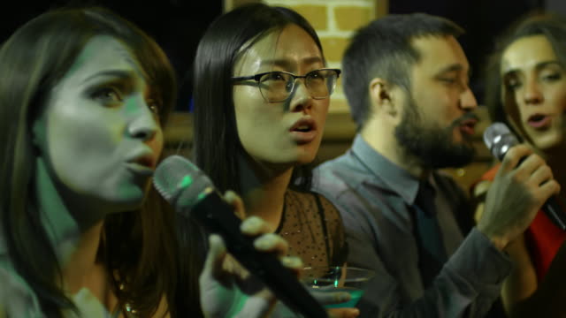 Junge-Menschen-singen-Karaoke-in-Nachtclub