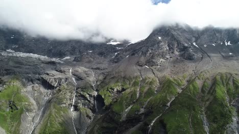 Drone-volando-hacia-atrás-en-el-fusión-glaciar-de-montaña