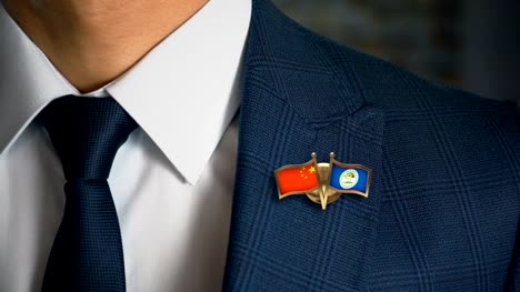 Businessman-Walking-Towards-Camera-With-Friend-Country-Flags-Pin-China---Belize