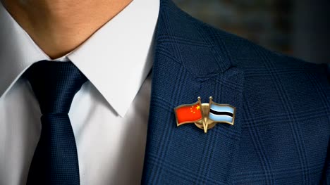 Businessman-Walking-Towards-Camera-With-Friend-Country-Flags-Pin-China---Botswana