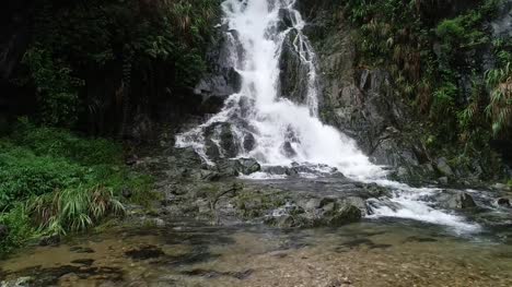 Asian-yoga--woman-meditation-near-waterfall-in-mountains