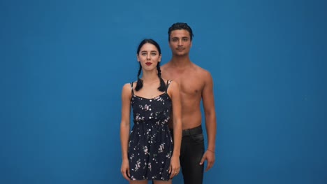 Joven-hermosa-pareja-hispana-posando-delante-de-la-pared-azul.-Mujer-y-hombre-guapo