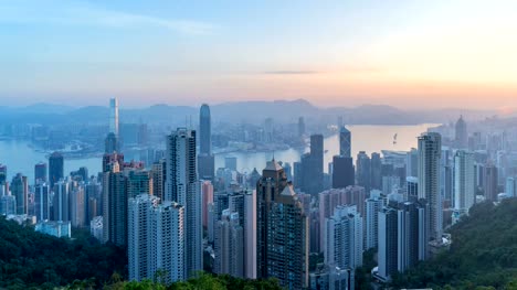 Zeitraffer-Nacht-zum-Tag.-Hong-Kong-Downtown-und-den-Victoria-Harbour.-Bankenviertel-in-smart-City.-Wolkenkratzer-und-Hochhaus-Gebäude-vom-Gipfel.-Luftbild-bei-Sonnenaufgang.