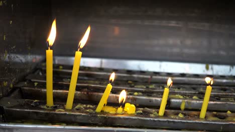 Burning-candle-light-in-front-of-Asian-temple---Faith,-spirituality-and-religion-concept