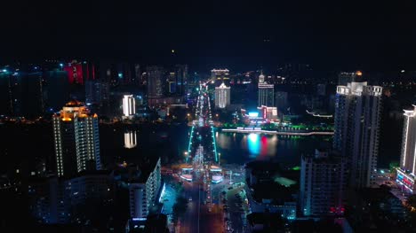 noche-iluminación-hainan-isla-sanya-ciudad-tráfico-calle-río-puente-aéreo-arriba-abajo-vista-4k-china