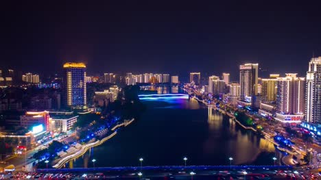 noche-iluminada-sanya-ciudad-río-panorama-aéreo-timelapse-4k-china