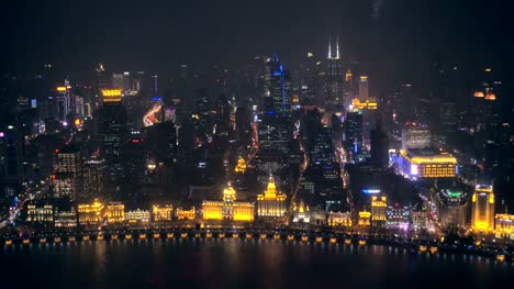 Embarcaciones-fluviales-sobre-el-río-Huangpu-y-como-fondo-el-horizonte-de-la-parte-norte-de-Puxi,-en-la-noche.