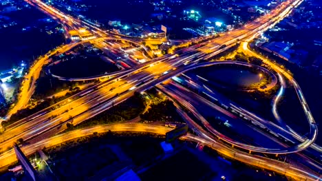 Timelapse-aerial-view-of-cityscape-and-traffic-on-highway-at-night.