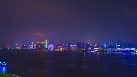 night-illuminated-wuhan-cityscape-riverside-megatall-construction-bay-panorama-4k-time-lapse-china