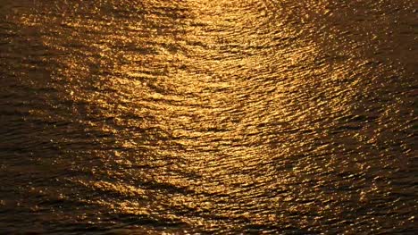 Schöne-warme-Sonnenuntergang-Reflexionen-auf-der-Wasseroberfläche