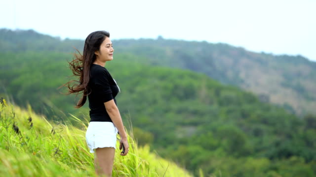 Asian-women-happily-standing-on-the-green-fields.