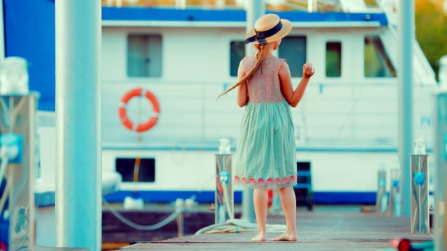 Schöne-rothaarige-Kind-Mädchen-geht-von-der-Anlegestelle-für-Boote-und-Yachten