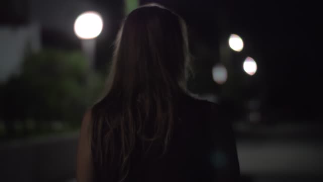 Frau-allein-zu-Fuß-in-der-Nacht-Straße