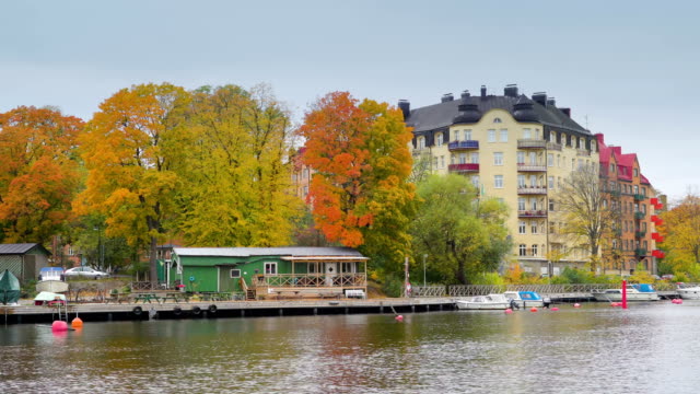 Small-green-house-and-the-boats-docked-in-Stockholm-Sweden