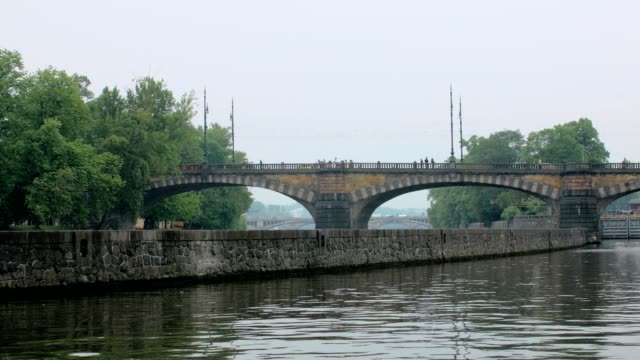 old-stone-bridge-over-Vltava-river-in-Prague,-between-shore