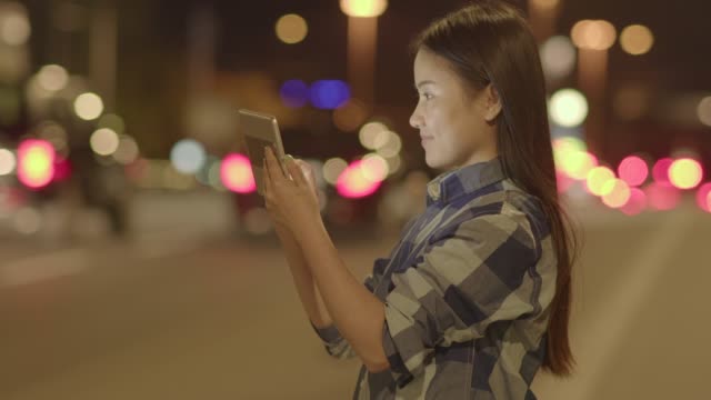 Mujer-feliz-comunicación-con-tableta-digital-en-ciudad-moderna