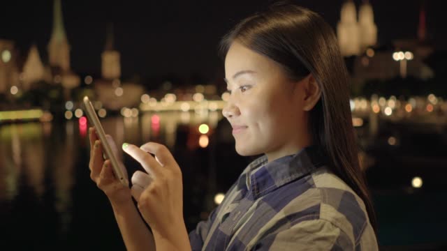 Mujer-feliz-comunicación-con-tableta-digital-en-ciudad-moderna