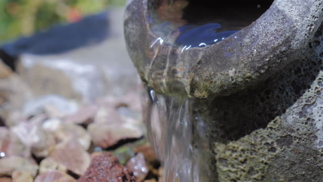 Outdoor-Brunnen-in-der-Form-eines-steinernen-URN-mit-Wasser-fließt