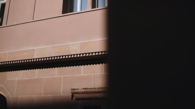Klassische-Gebäude-Außenwand-in-Frankfurt-mit-gravierten-deutsche-Schrift-an-Wand