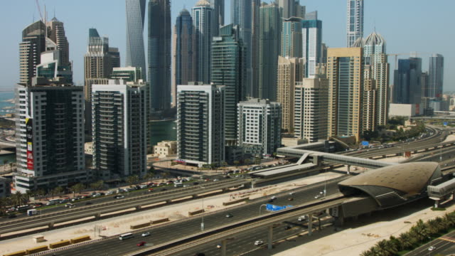 Pan-shot-of-towers-in-a-city,-Dubai,-United-Arab-Emirates