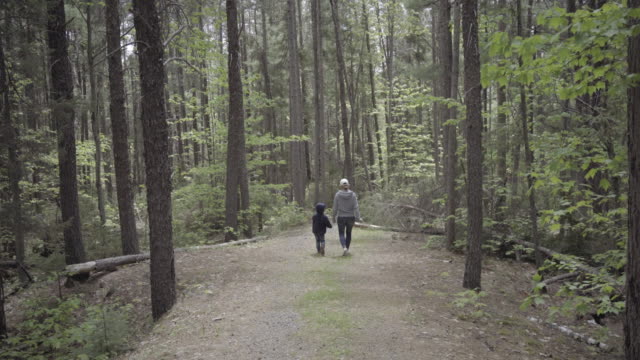 madre-y-el-niño-caminando-en-el-bosque-ontario-naturaleza-Canadá