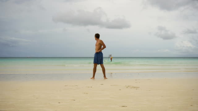 Hombre-haciendo-ejercicios-matutinos-en-la-playa