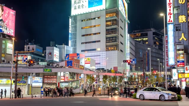 Timelapse-nocturno-de-turistas-caminando-a-la-estación-de-Shinjuku,-Shinjuku,-lapso-de-tiempo-de-4K-de-Tokio,-Japón