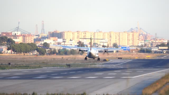 propeller-plane-landing-at-airport-runway,-rear-view