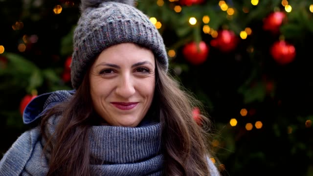 happy-pretty-Brunette-smiling-at-camera.-Christmas-time--outdoor