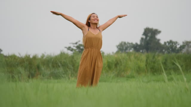 Beautiful-Young-Woman-standing-with-arms-raised-enjoy-in-nature