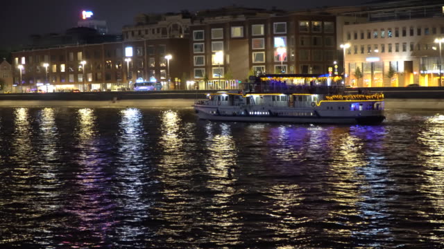 Nachtverkehr-von-Sportbooten-auf-einem-Fluss,-Stadt
