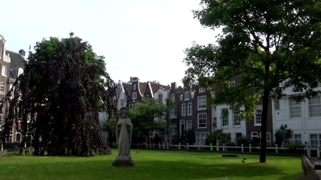 Una-pequeña-estatua-y-árboles-en-Amsterdam