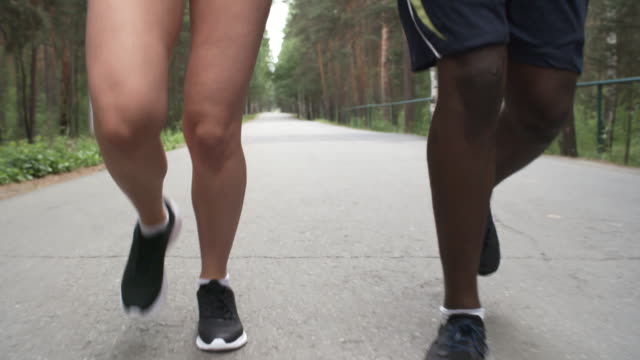 Frau-und-Mann-zusammen-Forstweg-entlang-joggen