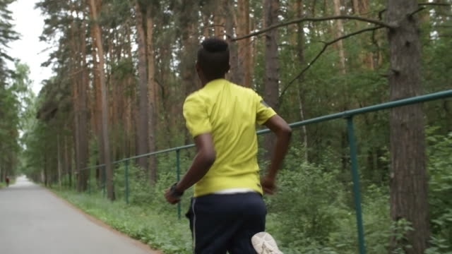 Sportliche-schwarze-Mann-läuft-im-Park
