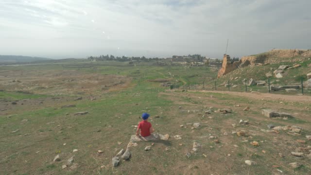 Niño-mirando-las-ruinas-de-la-antigua-ciudad-de-Hierapolis-en-Pamukkale,-Turquía